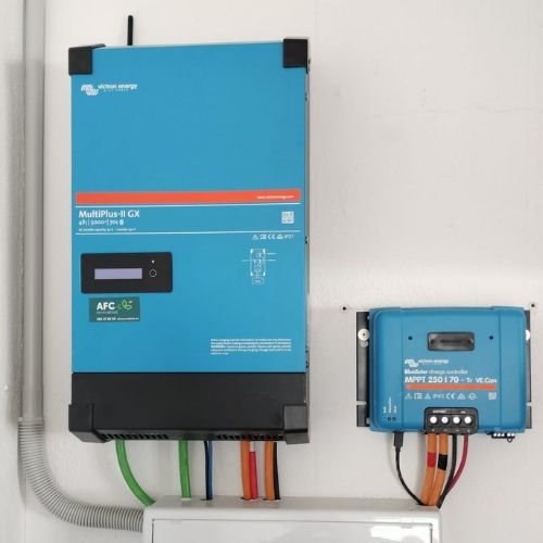 Componentes de un kit de fotovoltaica aislada profesional: inversor  y controlador de carga instalados en una pared.